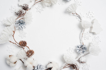 Christmas wreath made of wooden snowflakes, cotton flowers, pine cones and white flower pompons. White background. Flat lay, top view