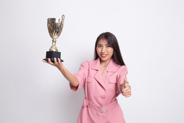 Successful young asian woman holding a trophy show thumb up.