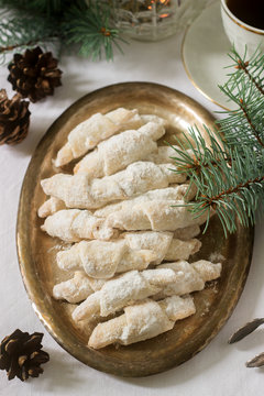 Traditional Moldavian shortcake cookies with jam stuffing and a cup of tea on the background of winter decor.