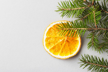 Fototapeta na wymiar Orange chips in the shape of a Christmas decoration on a fir branch. Eco organic homemade dried orange slices, chips. Healthy snack. Close up. Top view. Copy space