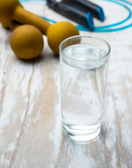 Dumbbells,skipping rope and glass of water after workout ,Fitness concept