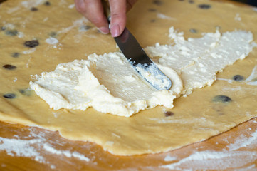 Spreading the curd filling with a knife on the dough