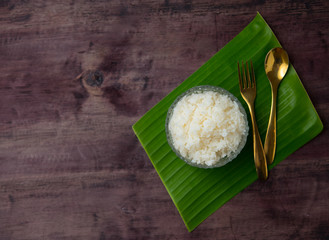 Thai jasmine rice in bowl with a spoon and fork on wooden table