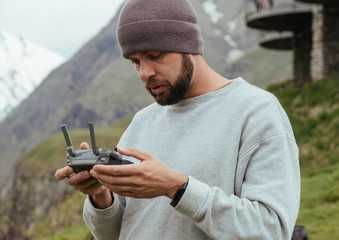 Drone operator pilot with beard in Georgian mountains