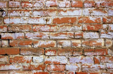  A shot of an old orange brickwork painted over with white paint. Vintage photo of the wall of an old building