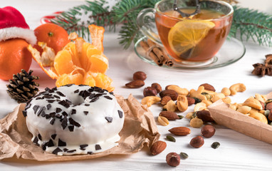 .donut, nuts and tangerines and branches of a Christmas tree on a white background