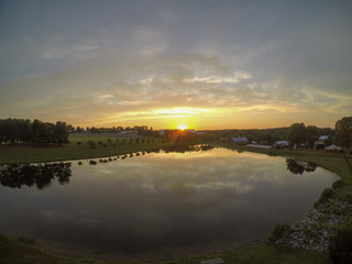 Large pond with the sky reflection at sunset as seen from an aerial drone