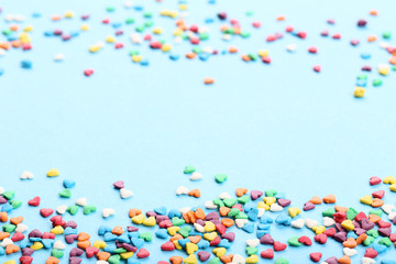 Colorful heart shaped sprinkles on blue background