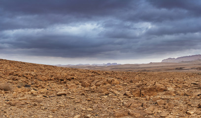 A rocky valley at the bottom of the canyon under low thunderclouds.