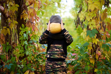 boy with pumpkin in the autumn forest