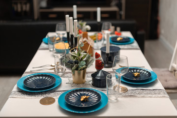 Home festive Christmas and New Year table setting in scandinavian style with rustic handmade details in blue and white tones