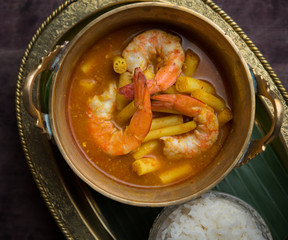 Sour curry soup with lotus stem and shrimp on black wooden table,Thai food