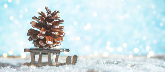 Christmas composition. Wooden sledges of Santa Claus and Santa Claus ride in the snow and carry a festive decoration a golden cone, the concept of Christmas and New Year