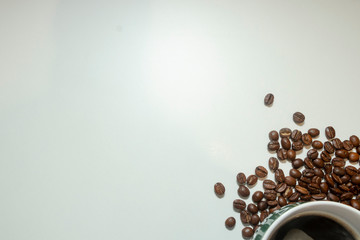 The cup of black coffee with coffee beans with wooden spoon. White background.