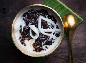 Black sticky rice with coconut milk on wood,Thai dessert