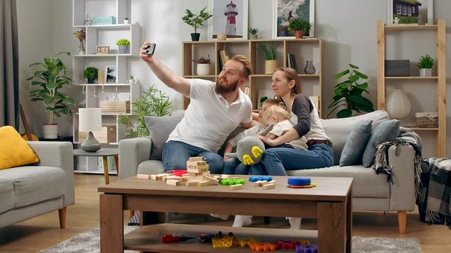 Happy family taking selfie at home on the couch