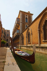 Classic wide-angle view of moored traditional gondola in water canal. Old buildings in the background. Sunny autumn day. Typical landscape of Venice. Italy © evgenij84