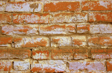  Close-up shot of an old orange brickwork. Old building, the wall on top is painted with white paint