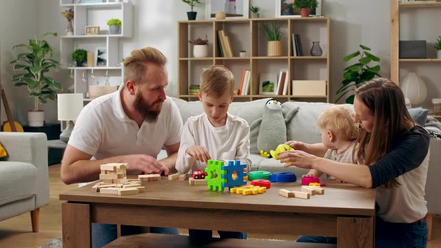 Happy family playing with toys on the table in the living room