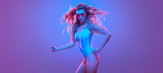Fashion contemporary neon style. Graceful Beautiful woman in party bodysuit dance. Disco summer vibes. Adorable fashionable sexy model. Fitness girl, trendy gel filter neon color. Creative art light