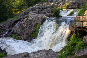 Finnish river running wild in the nature. Close photos of powerful water streams.