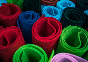 Colorful felt fabric - vivid background for your hobby, handicraft, textile decoration or design elements. Colored bright rolls of the felt as abstract background, top view.