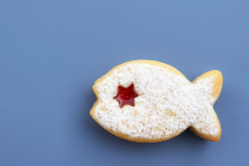 Linzer cookie in a shape of fish filled with red jam and dusted with powdered sugar 