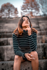 A young serious brunette sitting in the amphitheater of San Sebastian