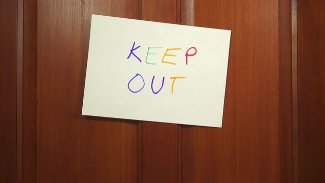 Door closing with a hand written KEEP OUT sign. Trying to get away from it all to find privacy and solitude.
