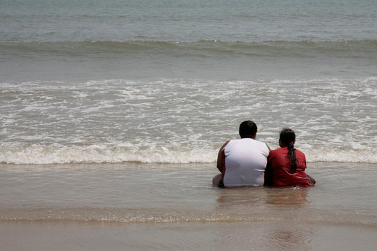 lovers sit in the sand on the beach
