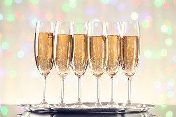 Glasses of champagne on blurred lights background