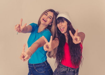 Portrait of happy girlfriends having fun isolated on neutral background