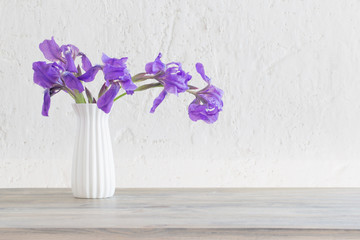 iris in vase on background white old wall