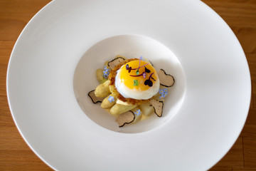 Fine dining poached egg with white asparagus, truffles and béarnaise sauce