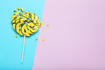 Broken lollipop candy on colorful background
