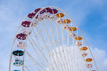 Upper part of ferris wheel with different colored gondolas
