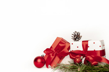 New Year or Christmas composition on a white background with gift boxes, with a red ribbon with fir branches, toys, copy space for congratulations