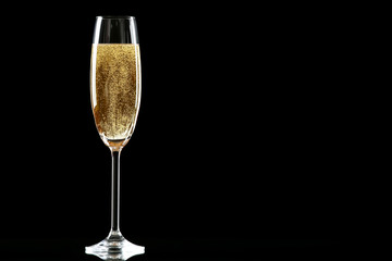 Glass with champagne on black background