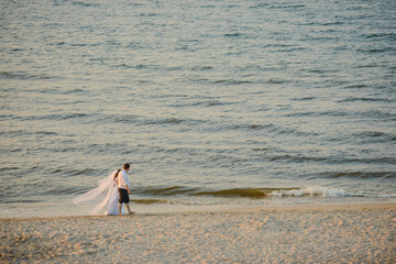 Fototapeta na wymiar Bride and groom at a photo session in the nature. Baltic sea beach