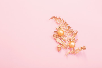 Christmas tree of painted golden leaves fern on pink paper backg