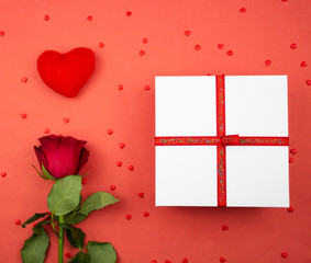 Present. Gift box on a red background. Hearts on a red background. Heart and red rose on a red background, hearts. copyspace. banner