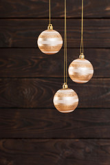 Fototapeta na wymiar Christmas balls hanging on dark wooden background