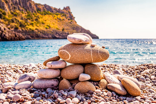 Abstract animal sculpture made of flat stones on the beach. Stone balancing is the art discipline, or hobby in which rocks naturally balanced on top of one another in various positions. Cala Bianca