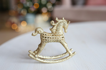 Horse, Christmas decoration, small children's toy gold color on the background of bokeh.