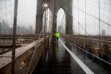 runner in Brooklyn bridge under the rain