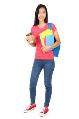 Young woman with books, paper cup and backpack on white background