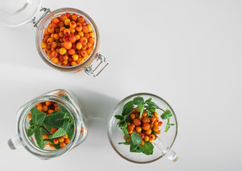 Winter drinks. Ingredients for making hot herbal tea. Tea with mint, ginger, lemon, sea buckthorn and honey. Top view.