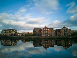 Belfast, Northern Ireland, Houses near Lagan River. Buildings reflection in water. 