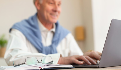 Fototapeta na wymiar Cheerful Elderly Man Working On Laptop Sitting In Office, Cropped