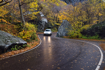 A car coming down from Highway 108 pass through boulders at Smugglers Notch State Park Vermont